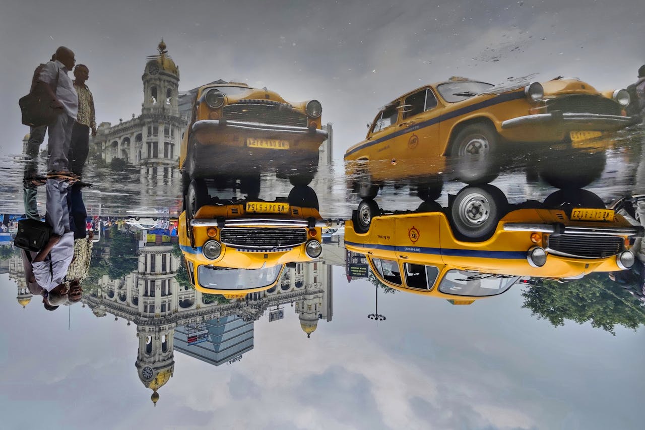 Delivering Results: Moving Pharma Supplies and Medicines between Kolkata and Sikkim Rainy day in Kolkata with iconic yellow taxis reflecting on wet pavement.