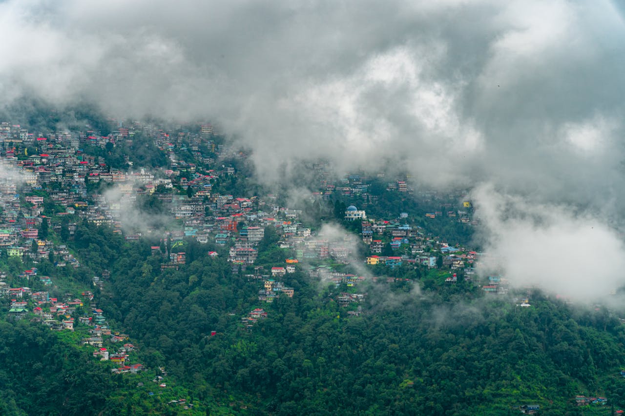 A scenic view of Darjeeling's colorful hillside under clouds.